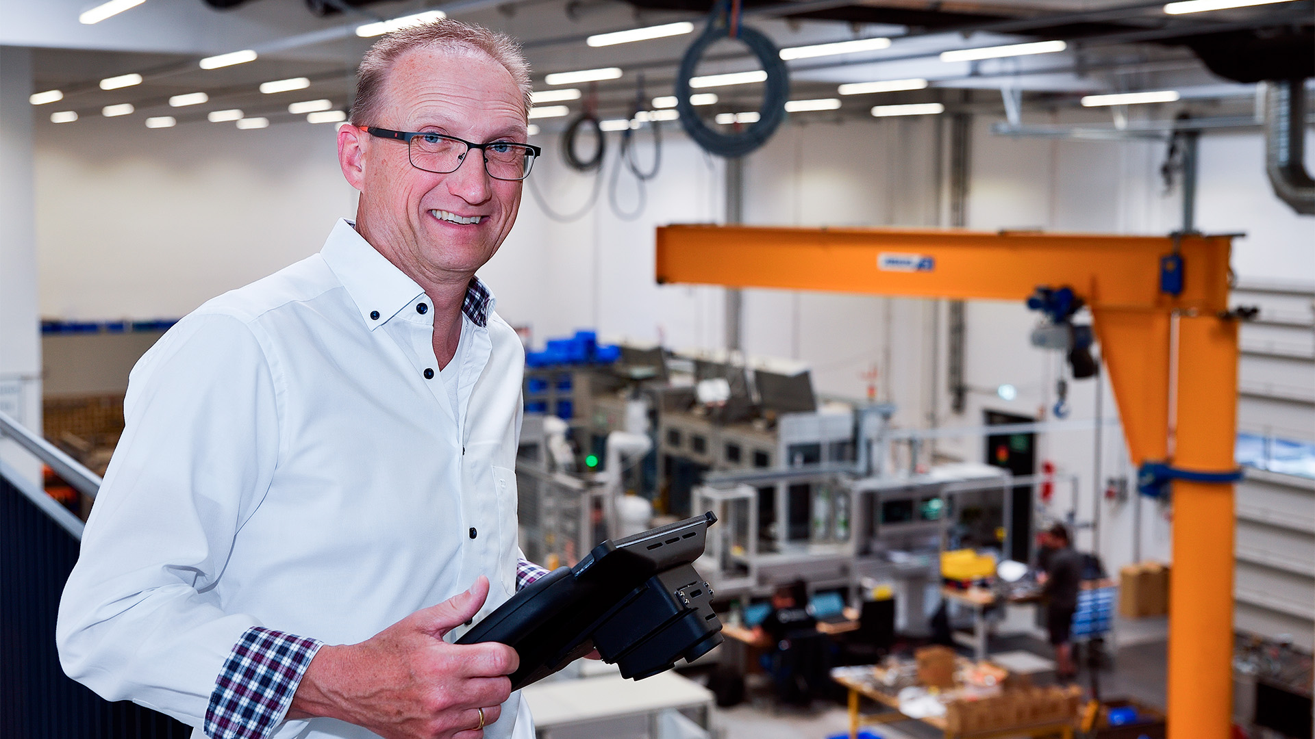 GEFASOFT Karriere - Mitarbeiter Produktion Mitarbeiter von GEFASOFT steht vor der Produktionshalle und blickt lächelnd in die Kamera